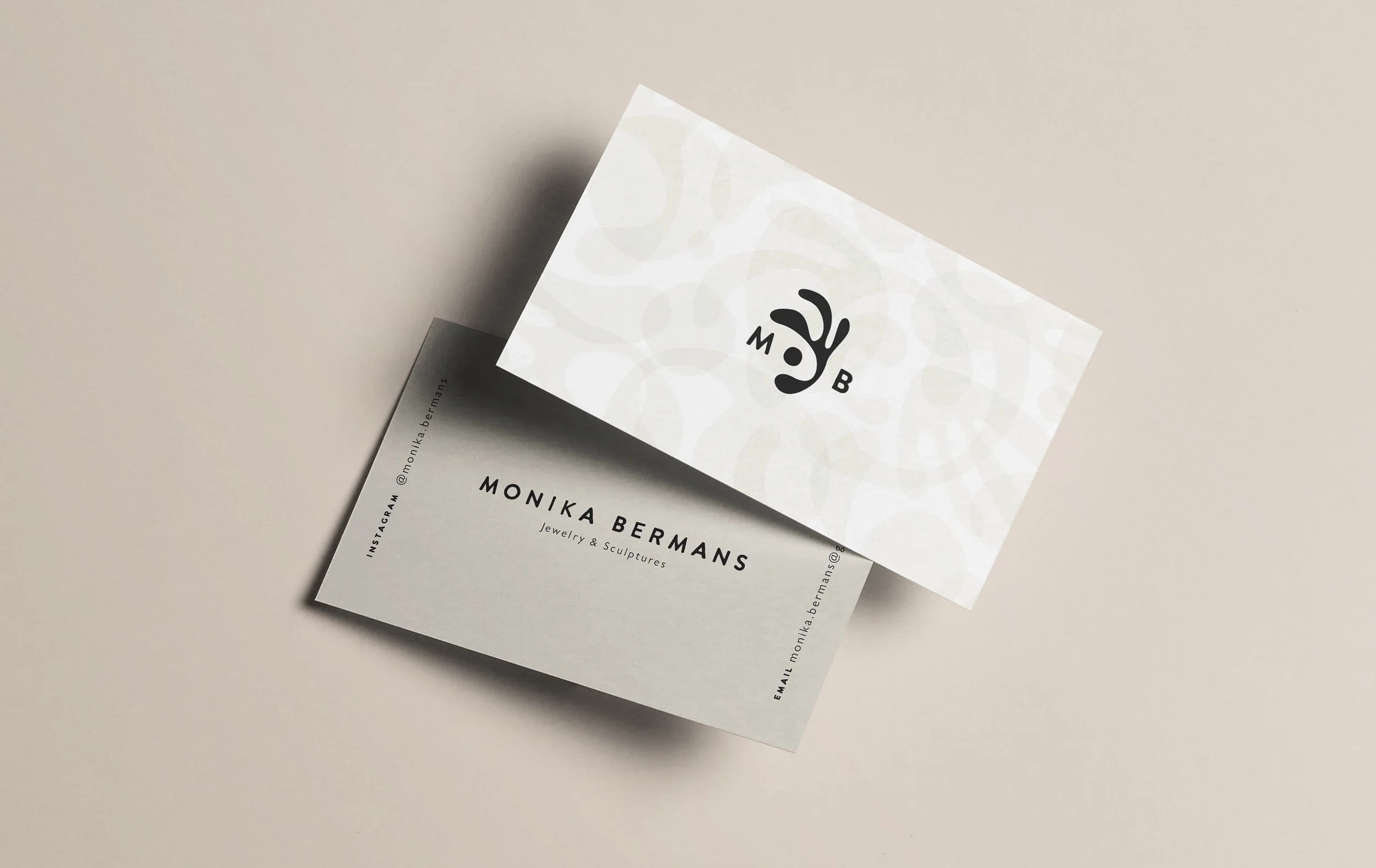 Business card for Monika Bermans with stylized logo and contact information on a white background.