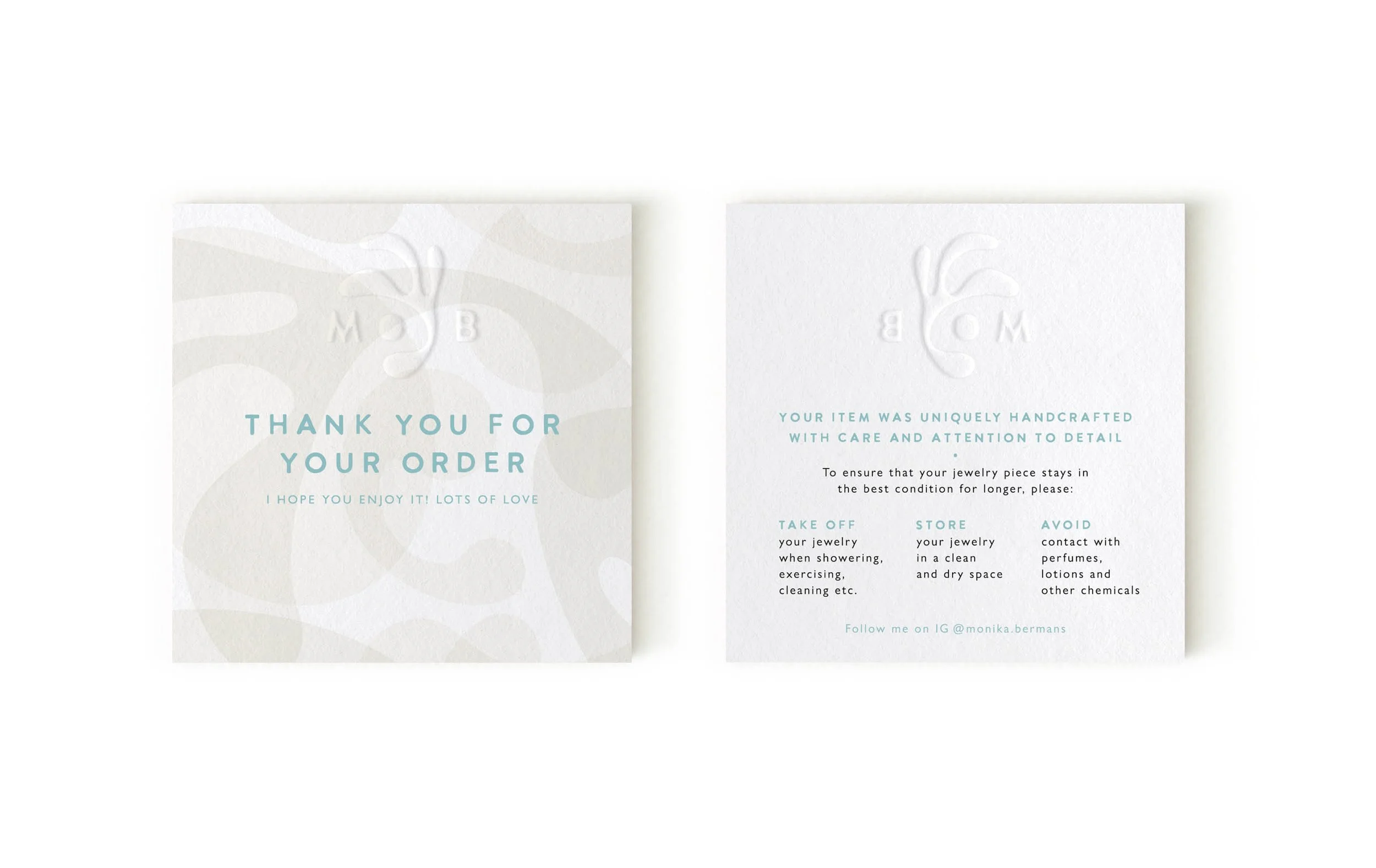 White paper gift card with embossed logo and light green text, framed by the back of a similar card, in soft pastel and minimalist design.