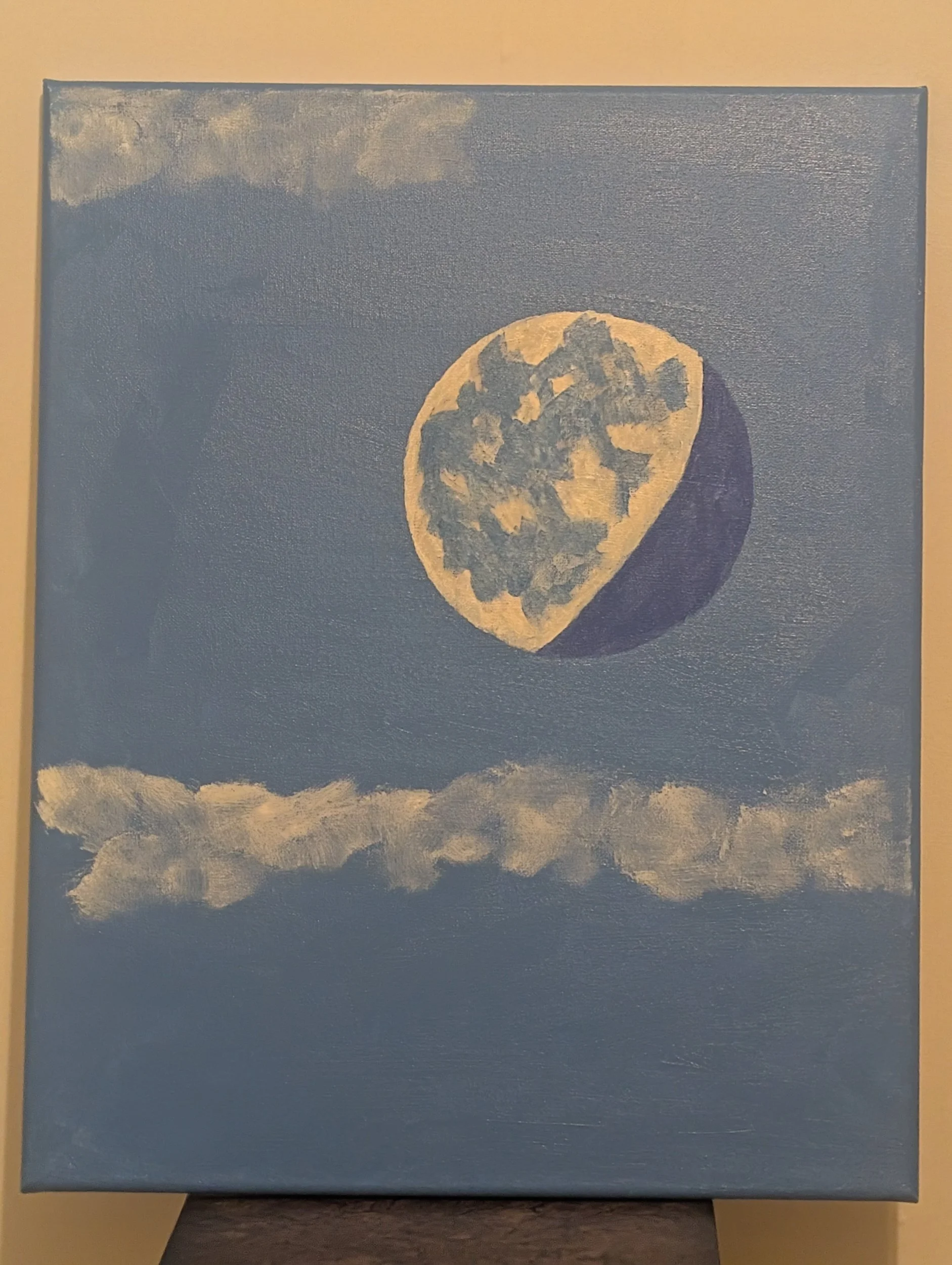 Painting of a large moon, partly hidden by clouds, against a blue sky.