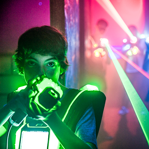 Teenage male holding up a laser tag gun