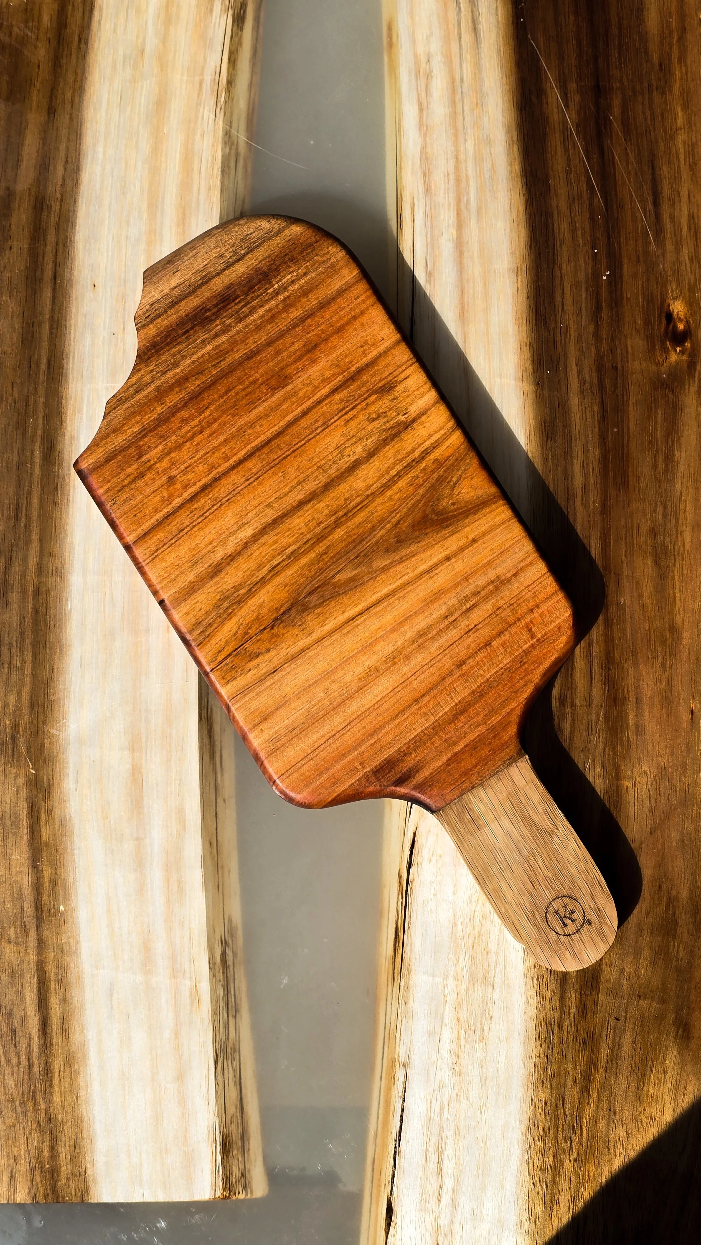 Tábua de cozinha de madeira com cabideiro de madeira ao lado.