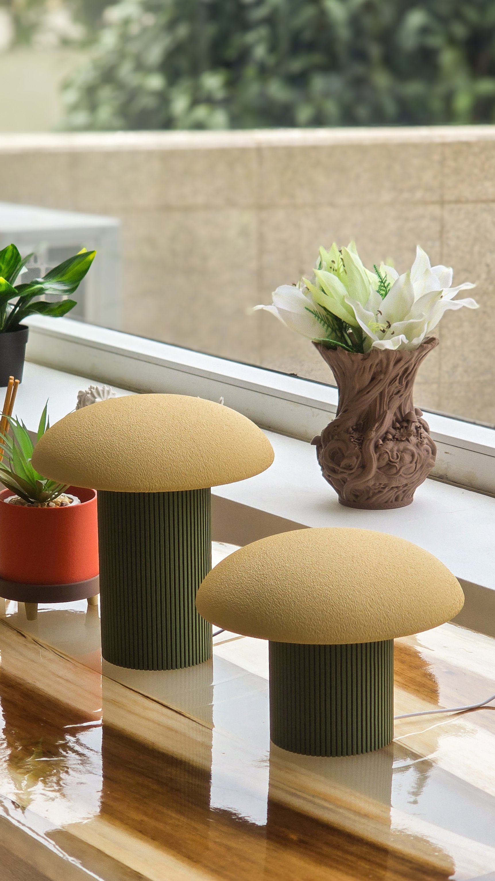 Vaso de flores brancas em uma mesa de madeira, acompanhado por plantas verdes, ao lado de cadeiras amarelas com pé de madeira.