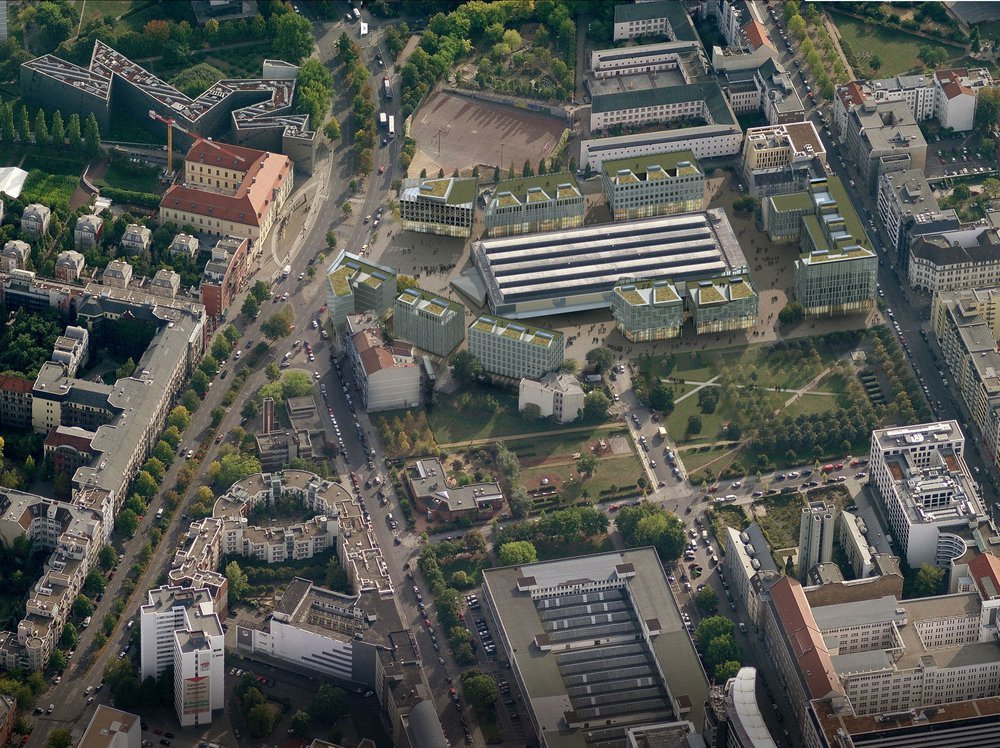 Aerial masterplan rendering for the Blumengrossmark redevelopment competition in Kreuzberg, Berlin. The birds-eye visualization integrates new glass-clad urban quarters with green living roofs.