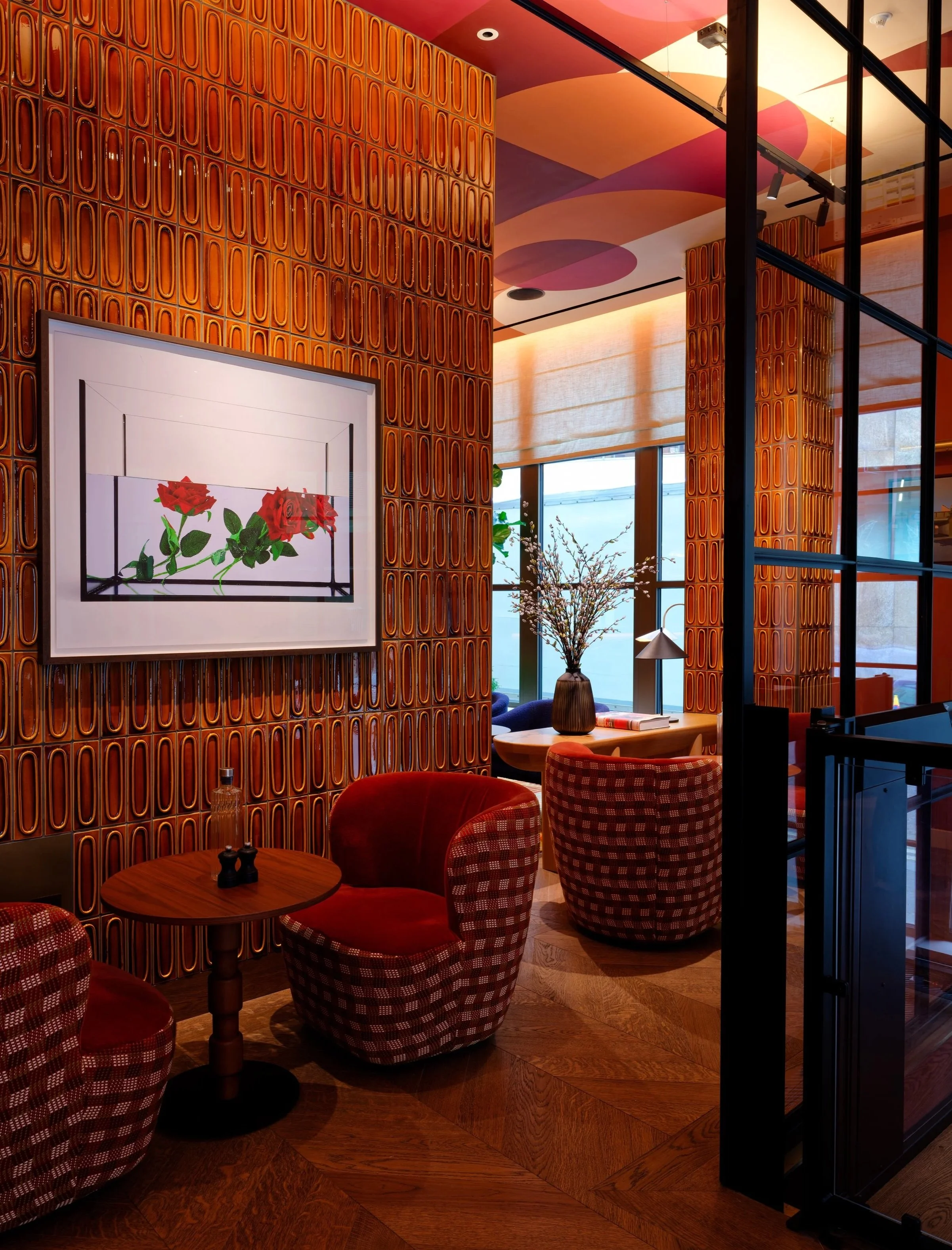 An interior photograph of a warm lounge seating area near the reception of the Wilde Hotel.