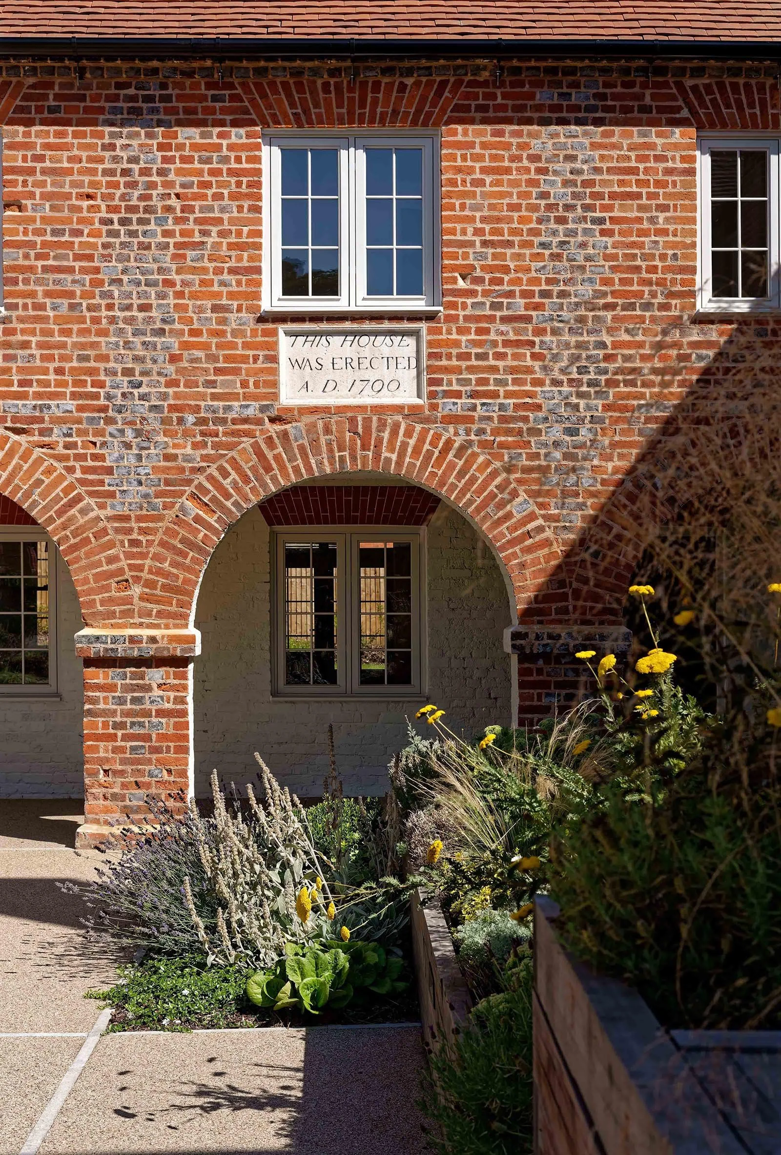 An internal historic courtyard view of a weathered red and brown brick 1790 workhouse.