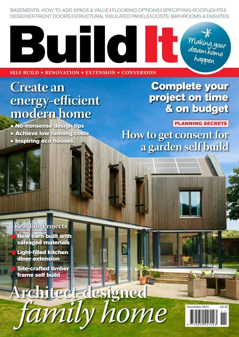Front cover of 'Build It' magazine featuring a modern, architect-designed family home with a wooden upper level, large glass windows and a patio with outdoor furniture. The magazine includes articles about energy-efficient homes, self-build projects, and renovation tips.