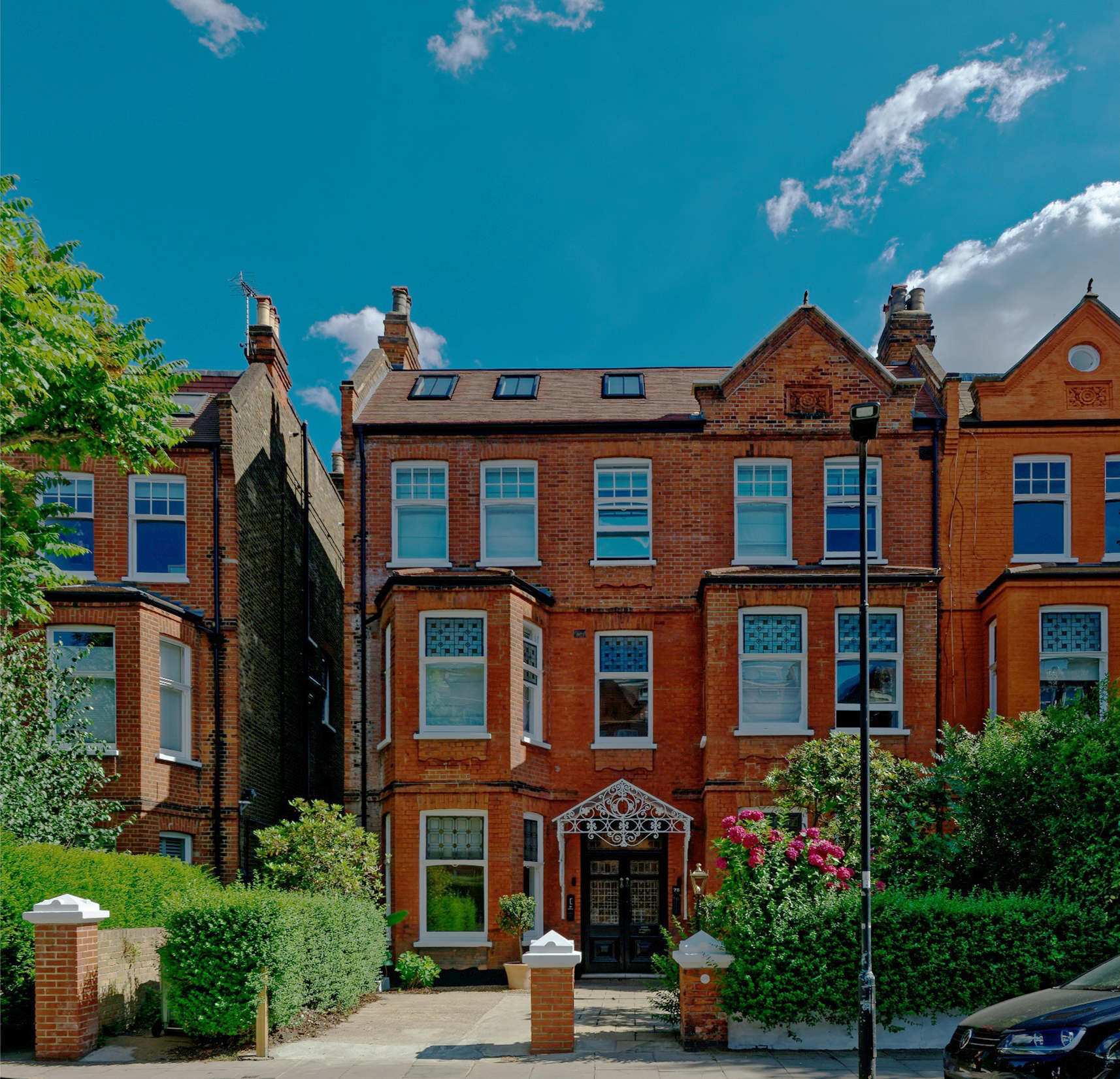 A street-level architectural photograph showing the historic front elevation of a red brick Victorian terrace building at Greencroft Gardens, Hampstead, London.