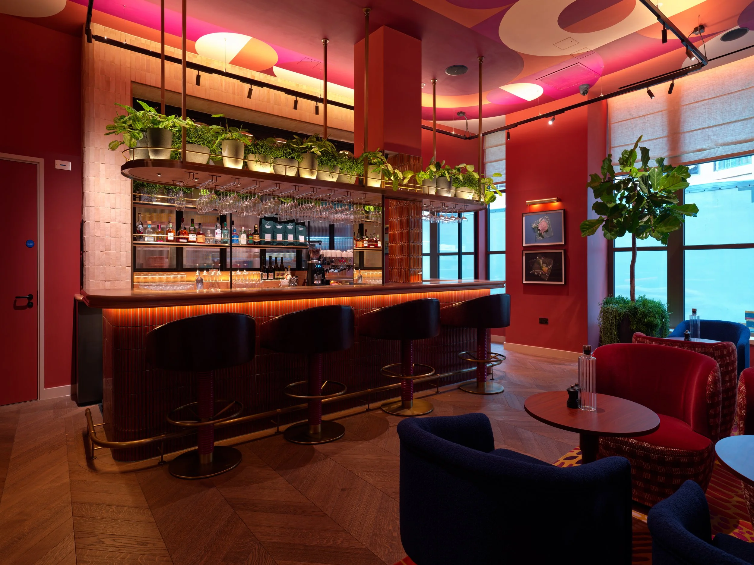 An interior photograph of the bar area and reception lounge inside the Wilde Hotel. integrated track lighting.