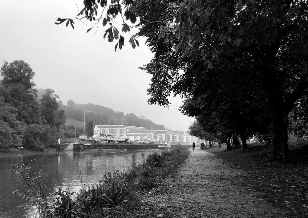 Photographic context visualization looking along a riverbank pedestrian path toward a proposed new waterfront retirement development on the River Dart in Totnes.