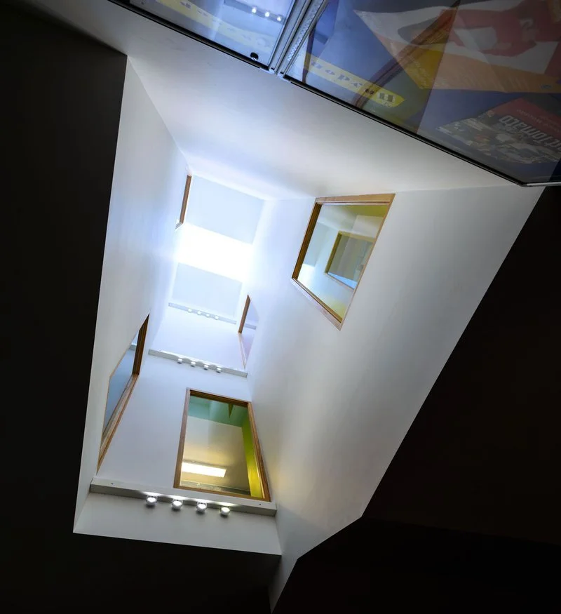 View of an indoor atrium or open courtyard with windows on multiple floors, taken from a low angle looking up.