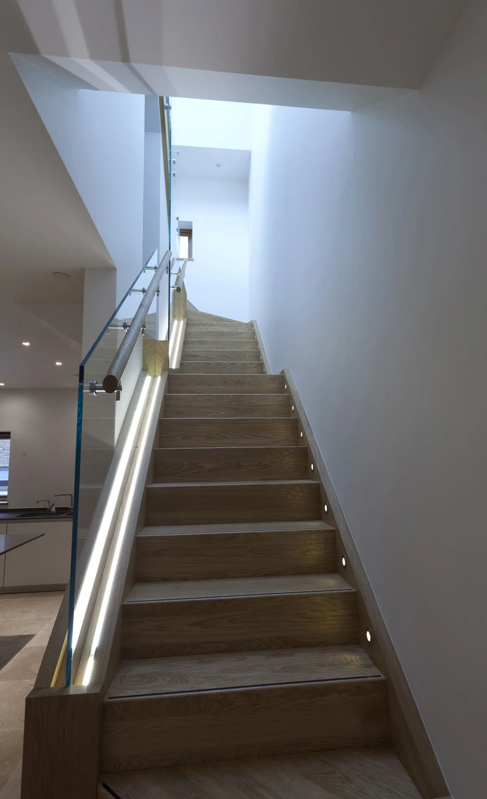 Modern interior design details by NBA showcasing a contemporary wooden staircase with integrated LED lighting.