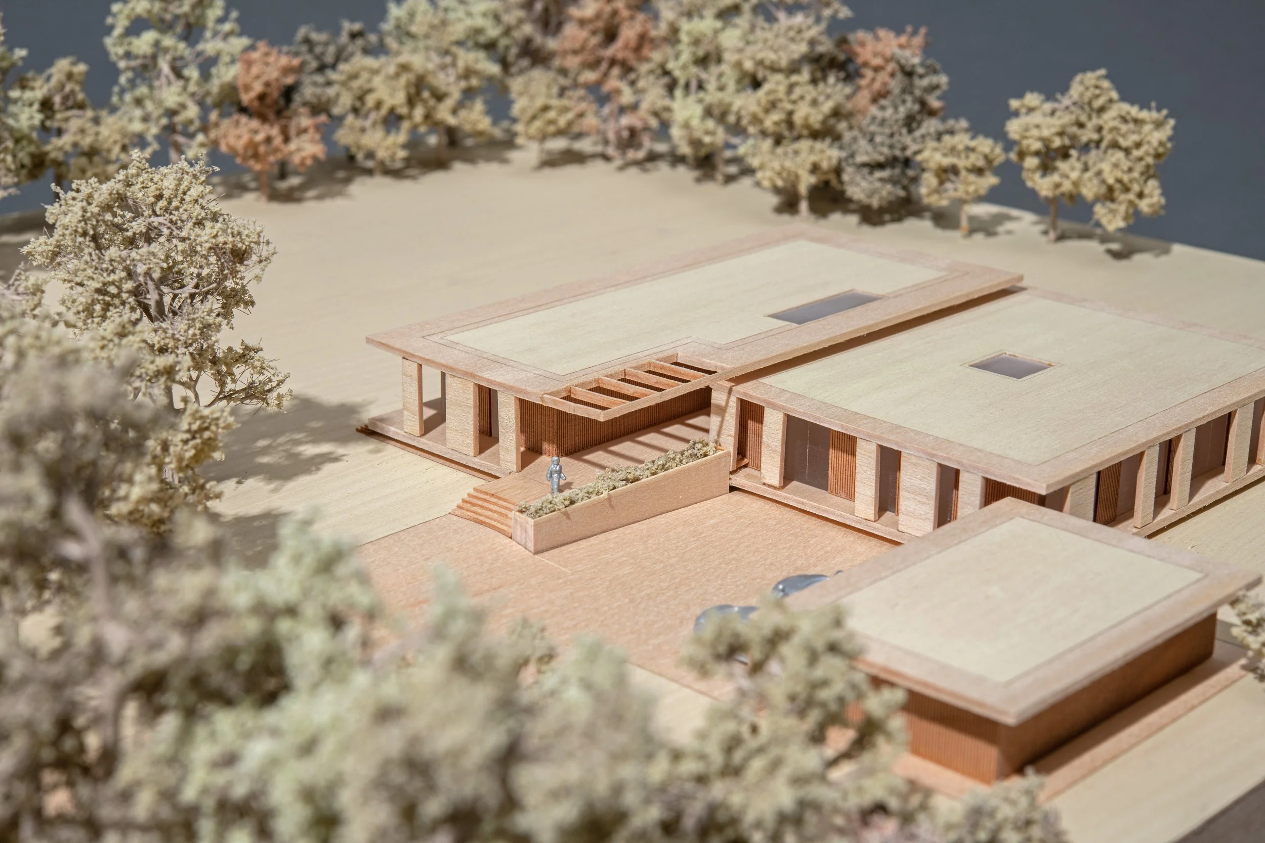 Architectural model of a modern house with surrounding trees.