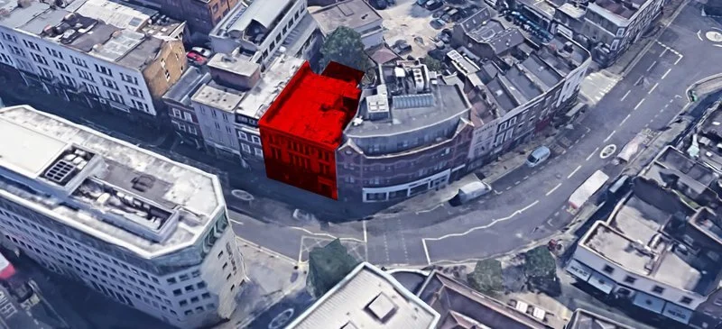 Aerial view of a city block with a building highlighted in red.