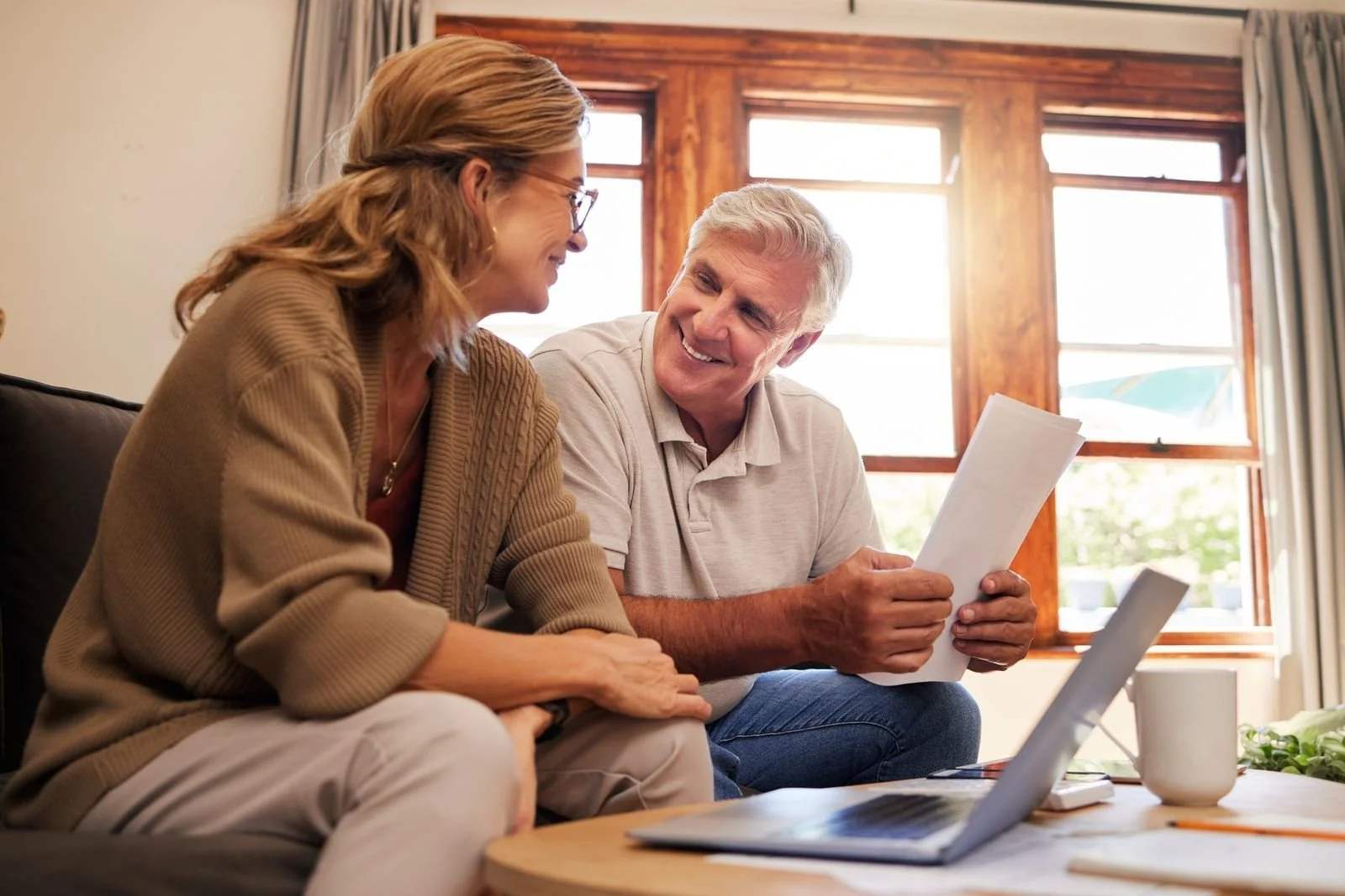 Older man reviewing benefit paperwork with a family member at home