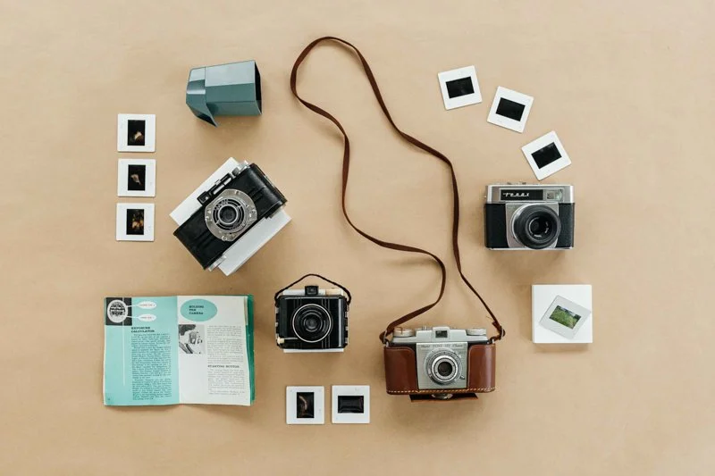 Various cameras and 35mm slides on a table.