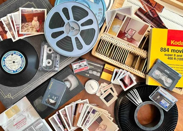 A table top full of various film, slides, negatives and movie film to be digitized.