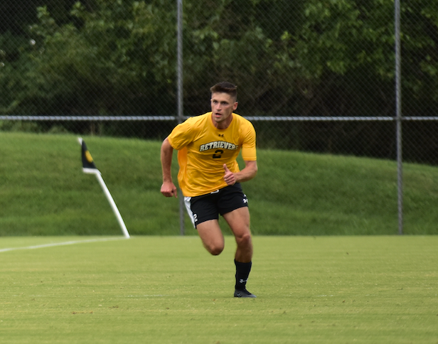 Soccer player in yellow jersey running on field near corner flag