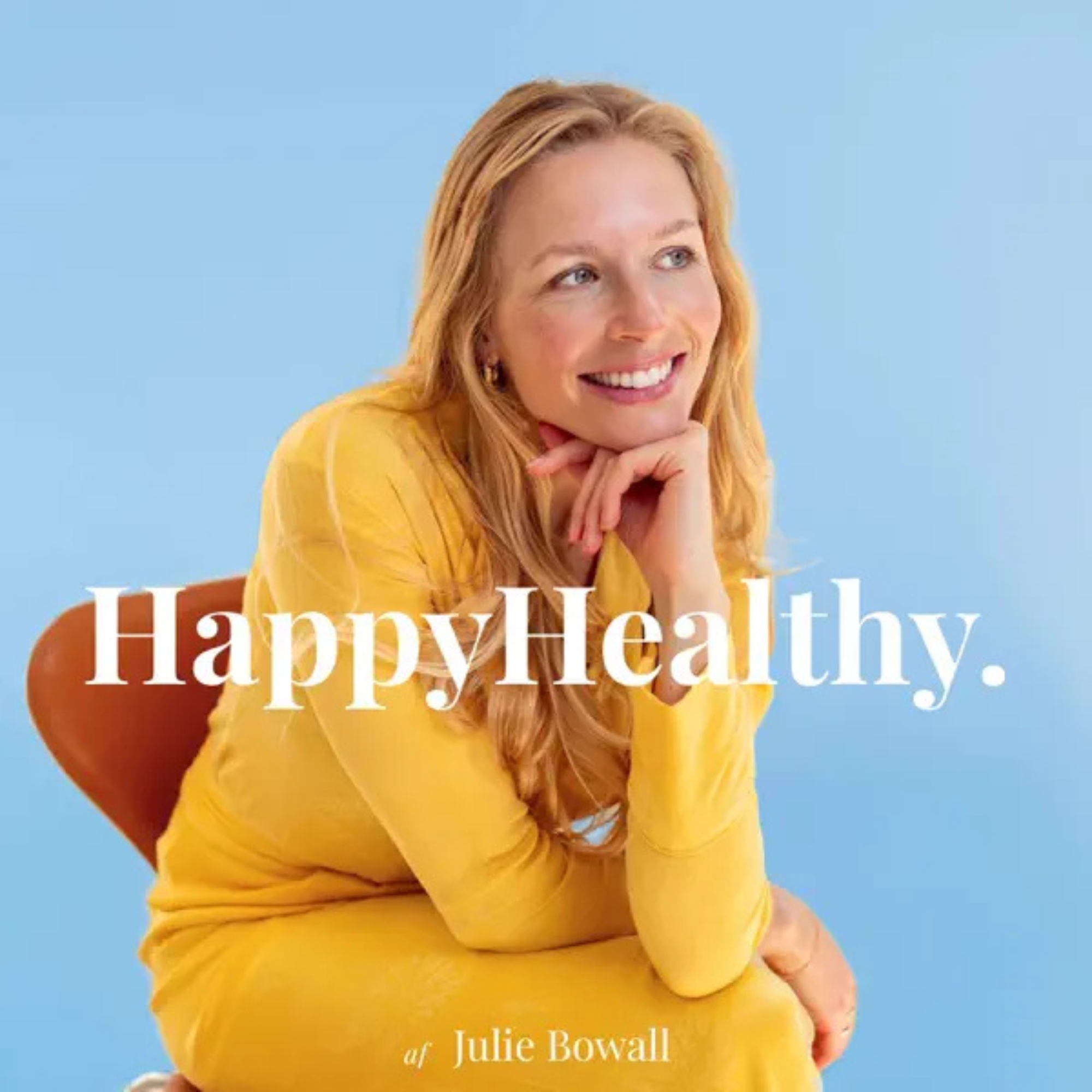 Billedet viser Billedet viser Happy Healths Spotify foto: en smilende kvinde med langt rødt hår iført en gul sweater, der sidder med hånden under hagen mod en blå baggrund. Overlagt er teksten: 'Happy Healthy af Julie Bowall'