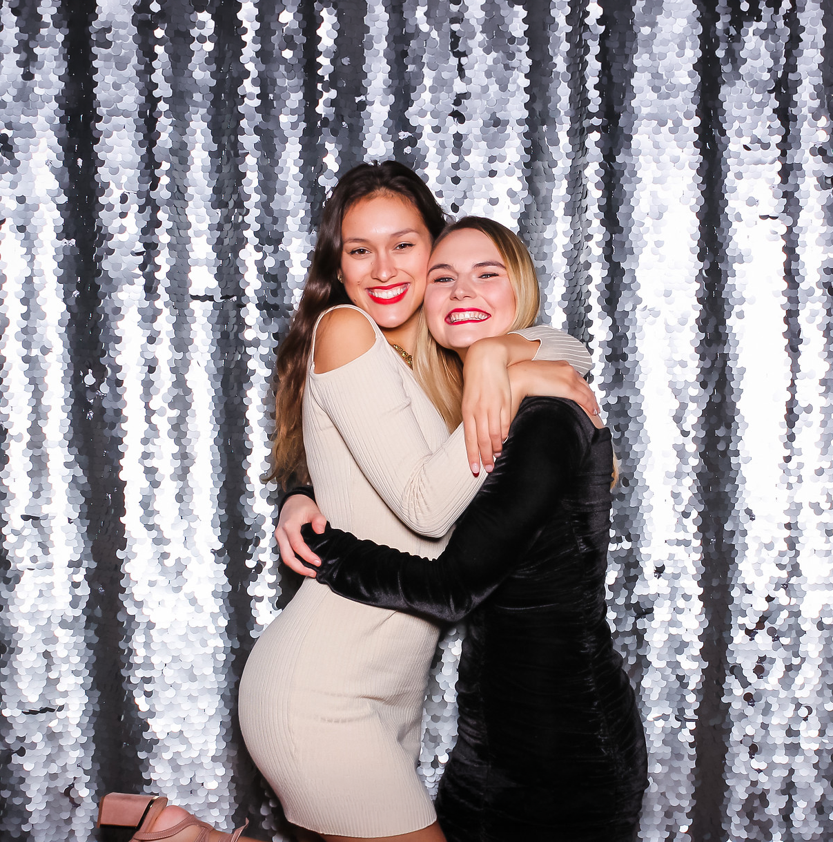 women hugging and enjoying a photo booth experience at a party