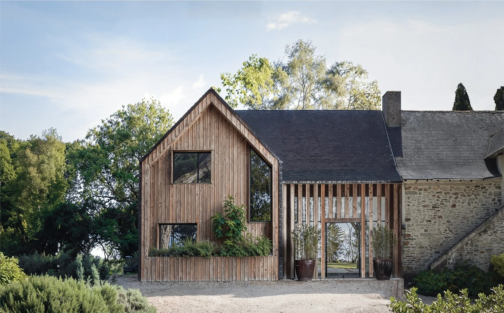 Insertion paysagère d'une extension en bois sur une maison en pierre