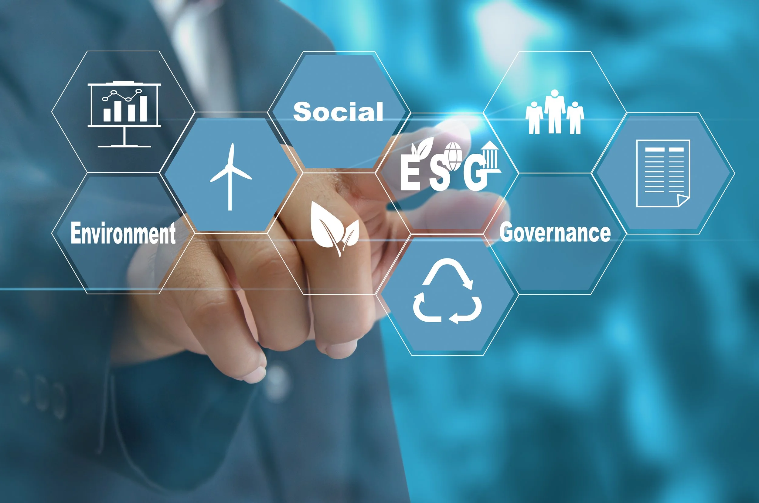 A person in a business suit interacts with a digital interface showing hexagons with terms like ESG, Environment, Social, Governance, and icons representing data, wind energy, recycling, and sustainability.