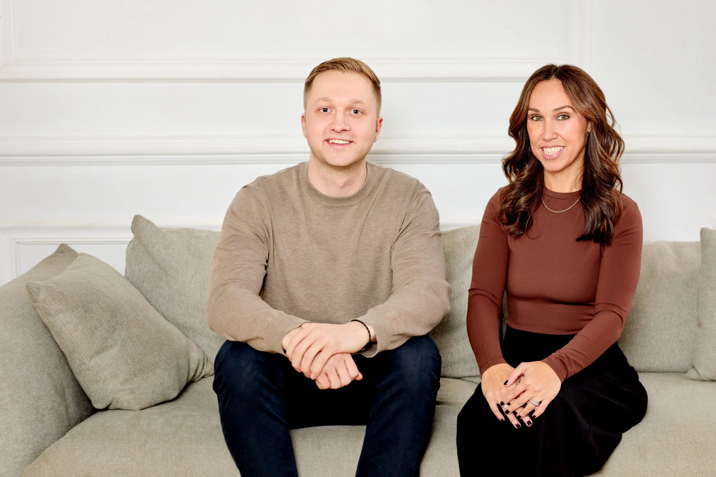 Therapists Jack Szary, LMHC-D, and Lindsay Levine, LMHC, of Rhythm Wellness seated together on a couch