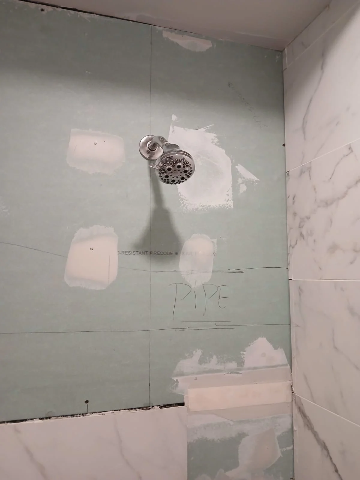 Drywall repair in progress in Brooklyn apartment, showing exposed wall before tile installation after fixing PVC pipe leak by New York Wall Repair