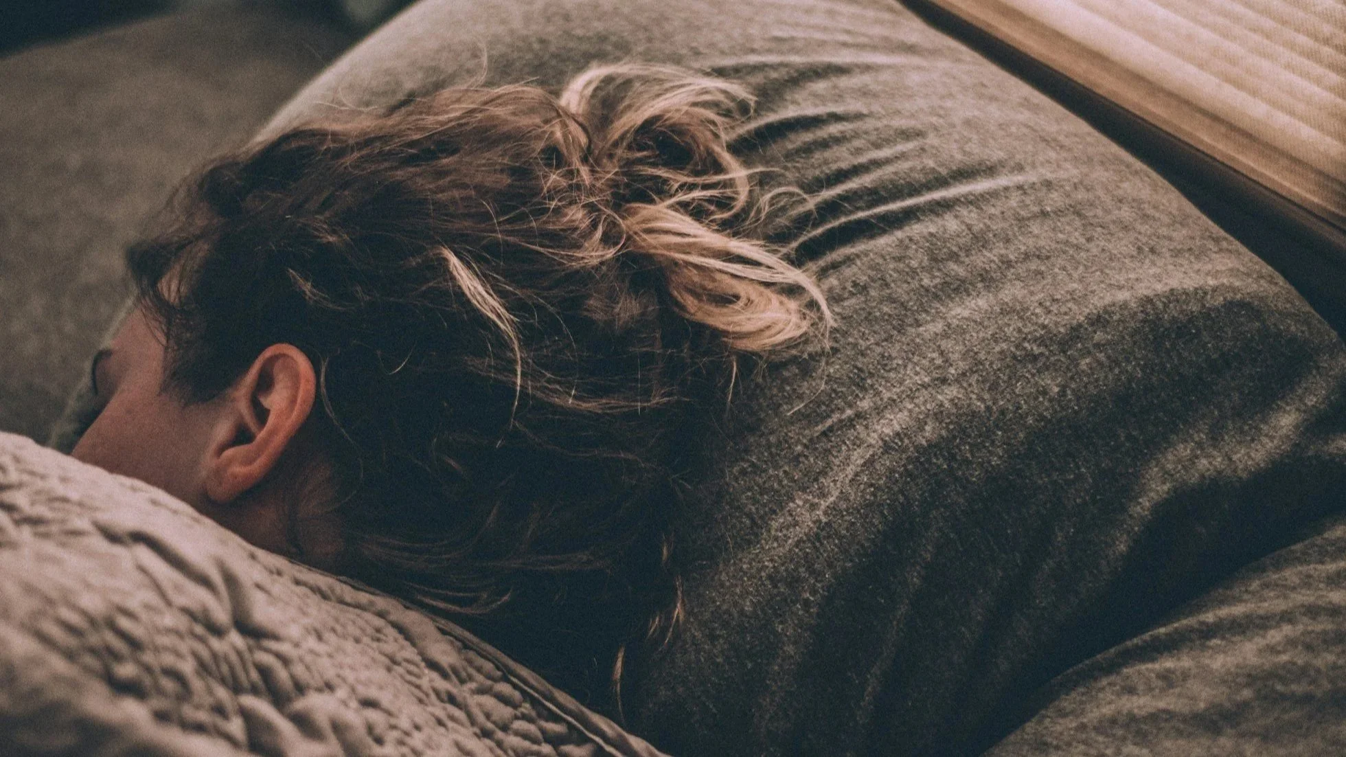 A person enjoying deep, restful sleep after a RECUVR sauna session, highlighting the benefits of heat therapy for melatonin production and REM cycles.