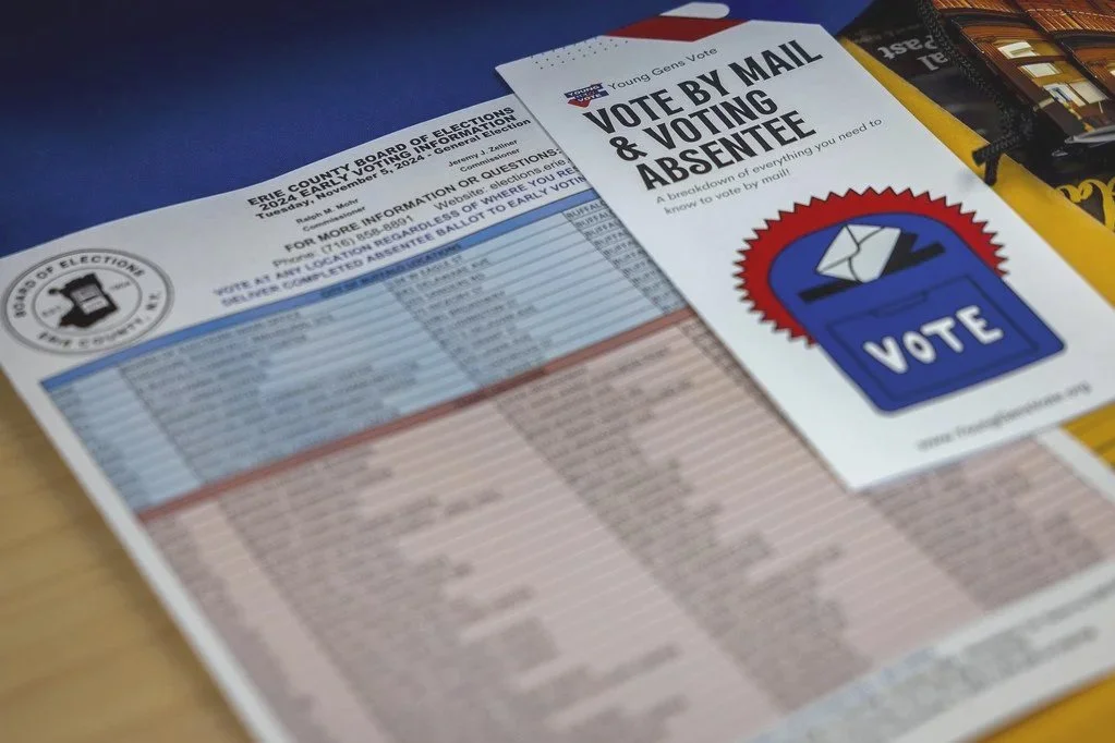 Mail-in ballot and voting information brochure on a table, with the title highlighting voting by mail and absentee voting.
