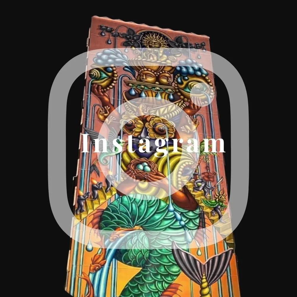Colorful carved wooden panel depicting a mythological figure with a lion's head, a fishtail, and various intricate details, set against a black background.
