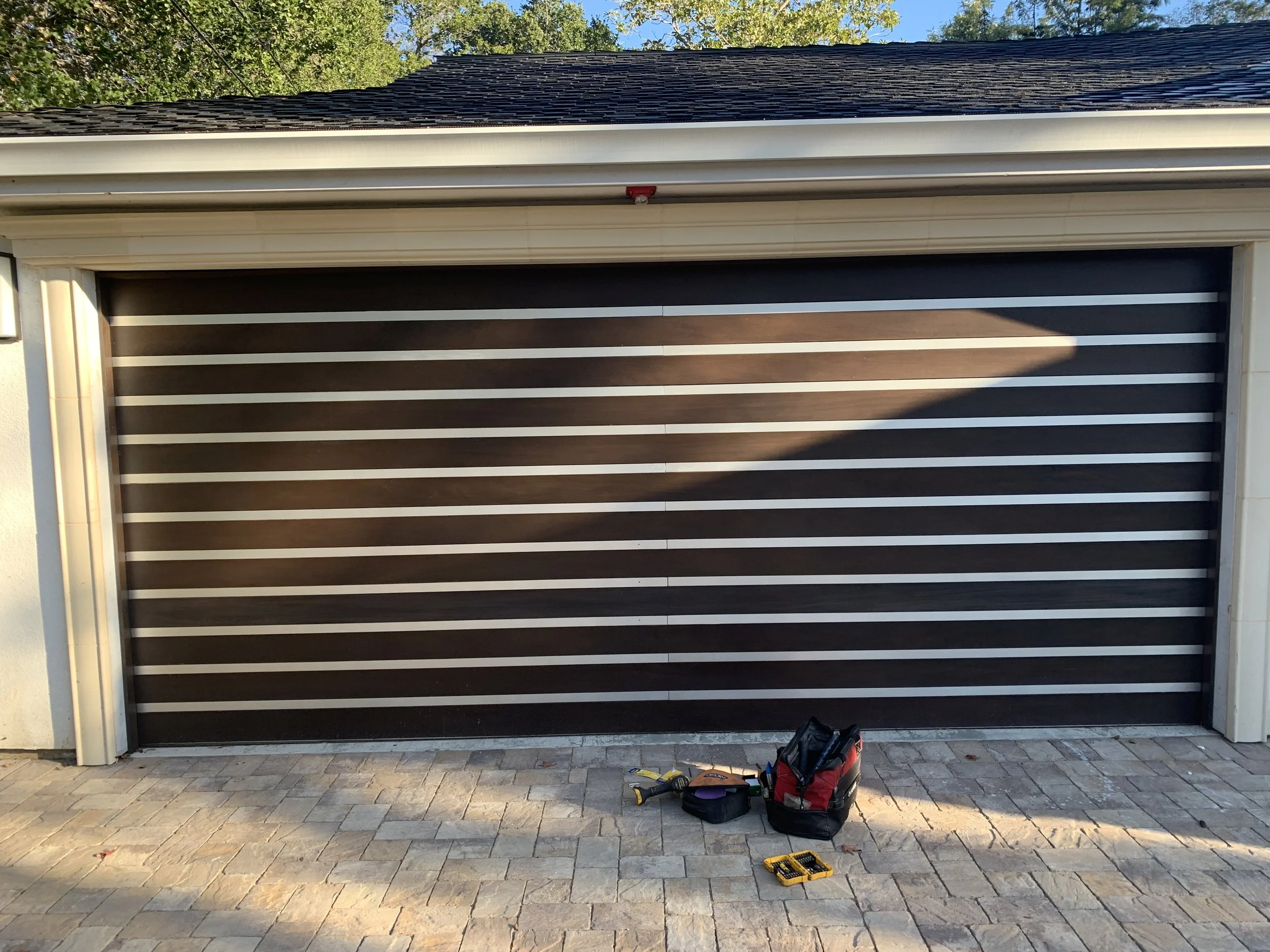 2 car garage door wood grain stone house