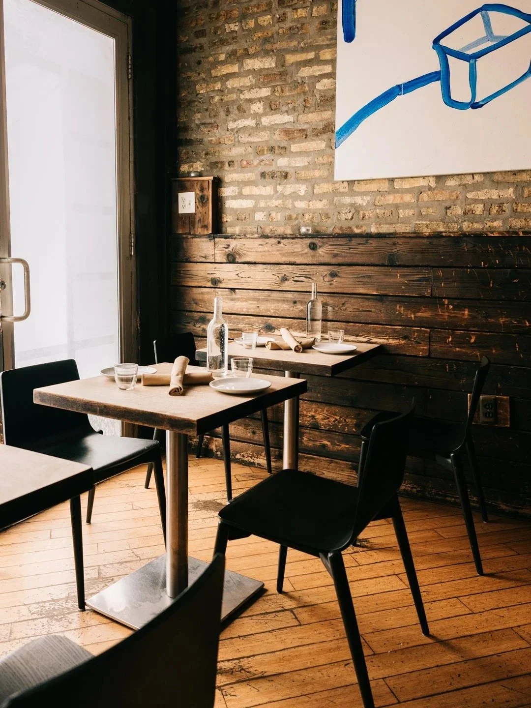Cozy tables along the brick wall at Table, Donkey and Stick in Logan Square