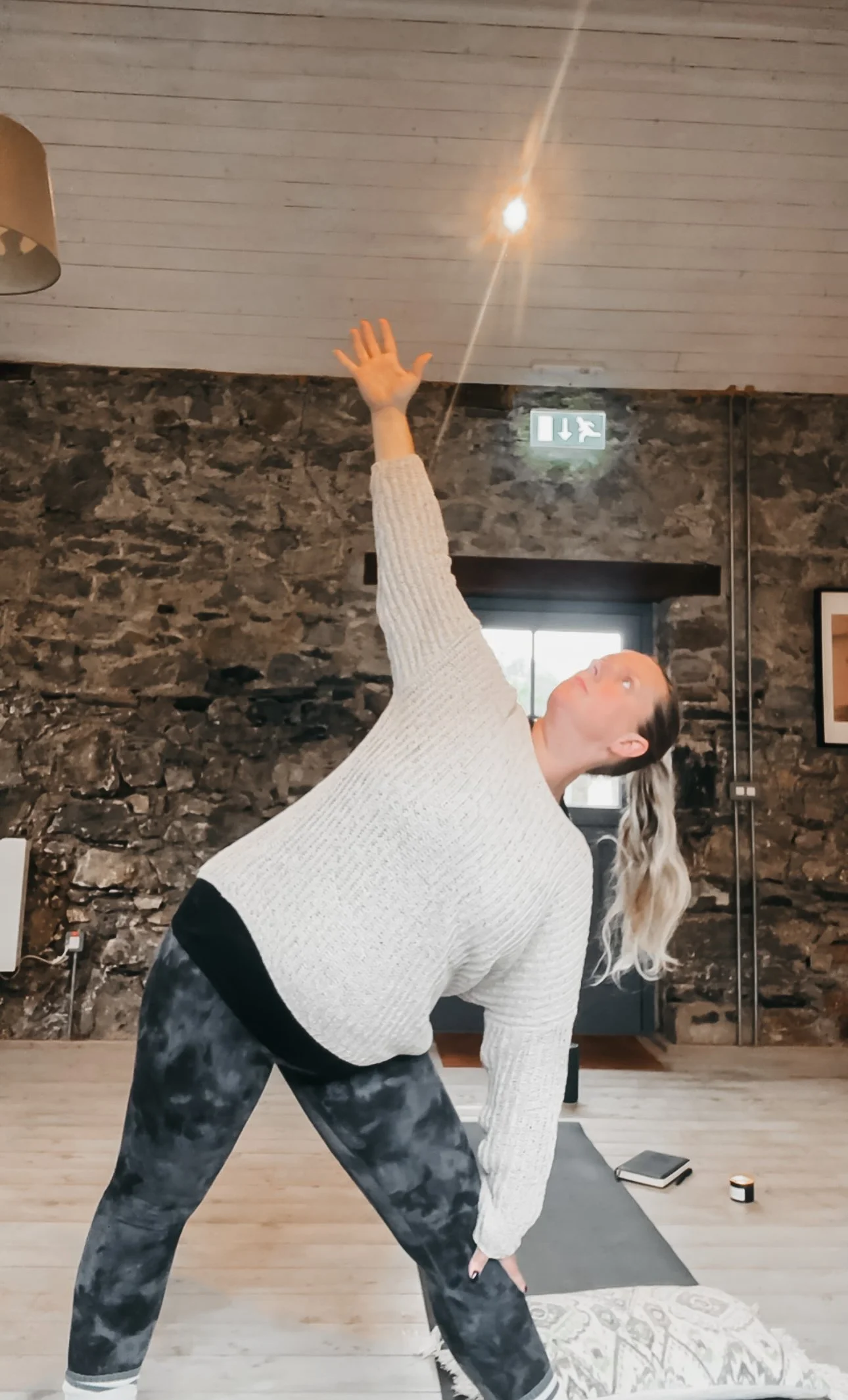 Woman doing standing yoga pose while pregnant