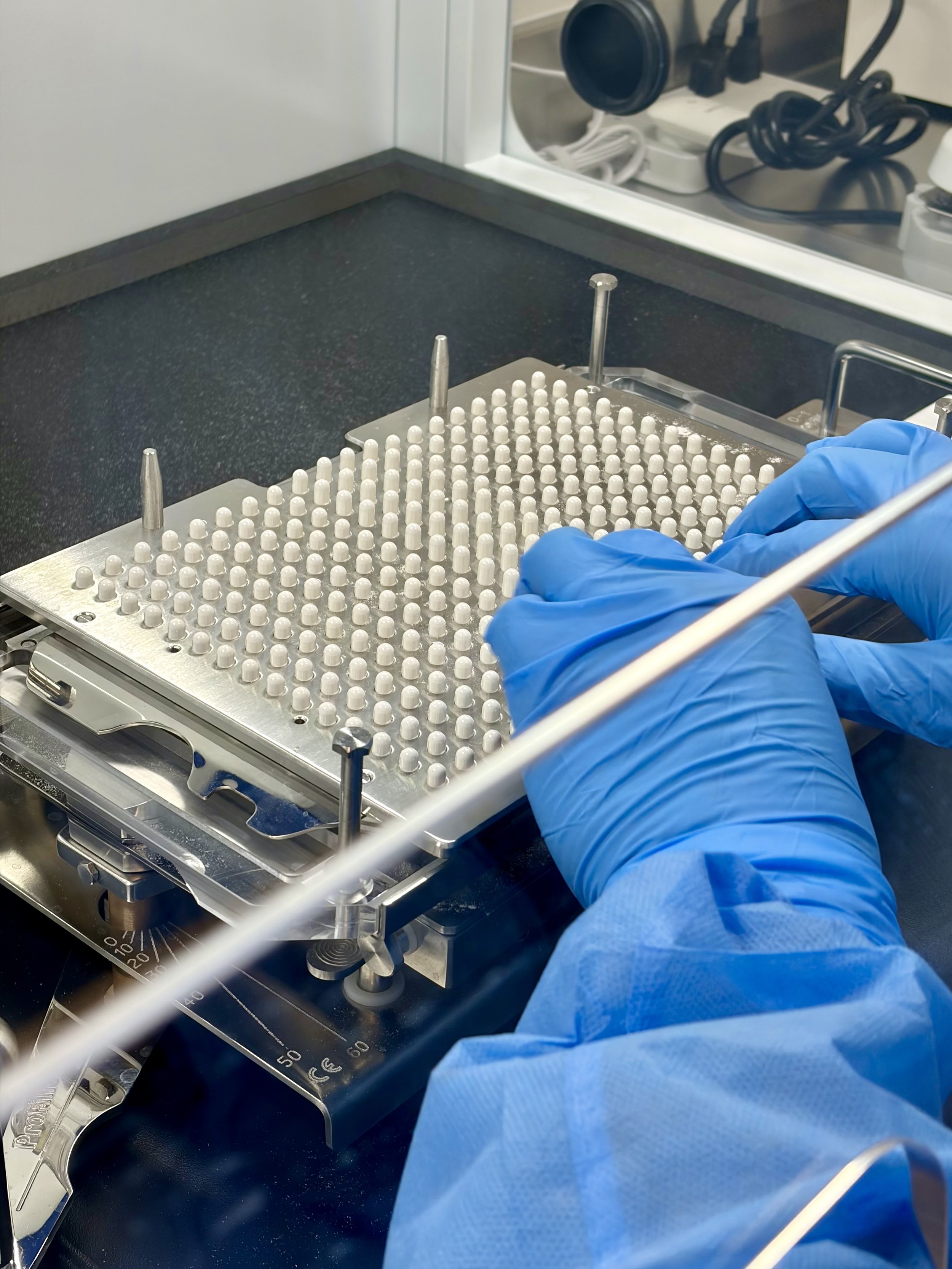 Pharmacist filling capsules with a medication compounded for a patient of Campbell's Drug.