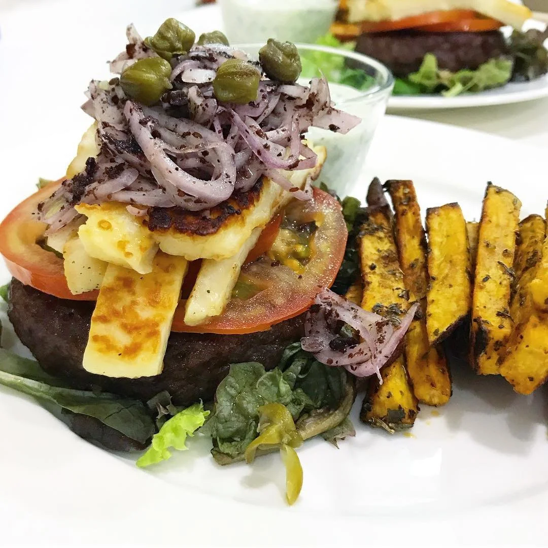 Back to the kitchen with this uber delicious Mediterranean-influenced burger. Burger was grilled to perfection on a bed of local greens, topped with local tomatoes, sizzling halloumi cheese, red onions in a lemon-sumac mixture,  and capers. Side of b