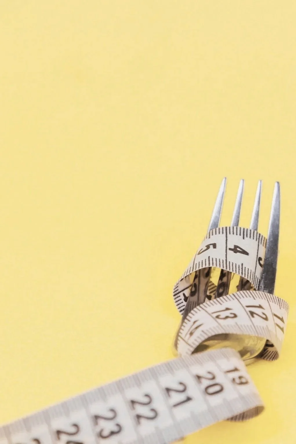 Tape measure wrapped around fork symbolizing eating disorders.