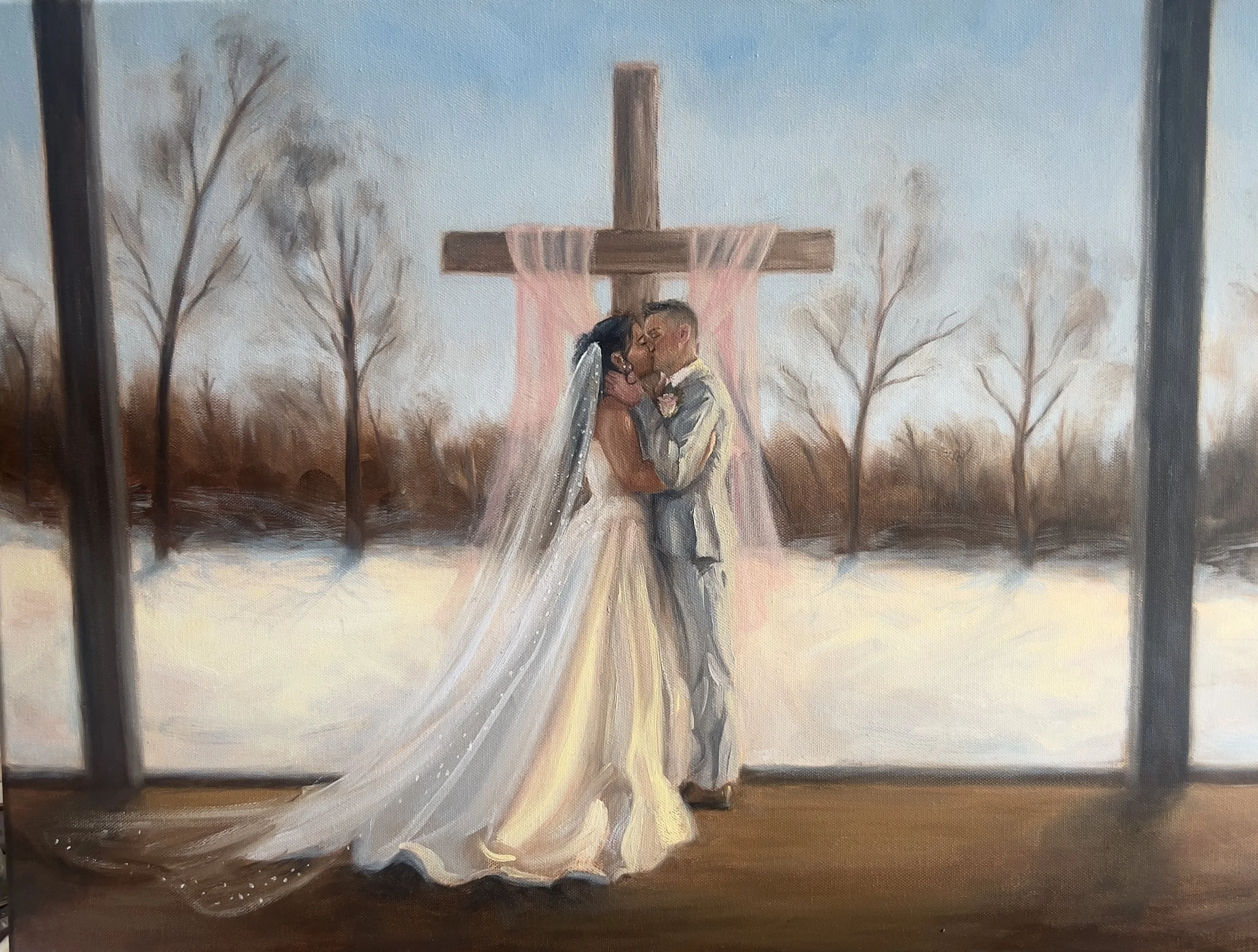 A wedding painting depicts a bride and groom kissing in front of a large wooden cross draped with pink and peach fabric, with leafless trees and a snow-covered landscape in the background.