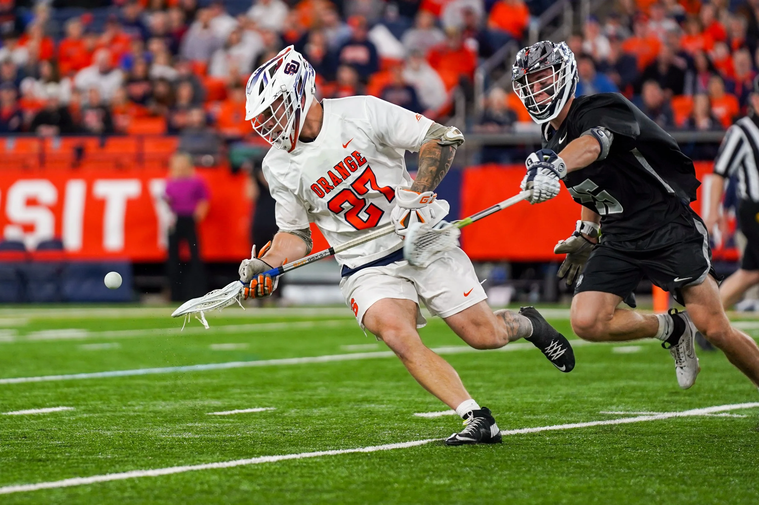 Syracuses John Mullen #27 after faceoff grabbing ball from Georgetown University player during mens lacrosse game in JMA Wireless Dome. Photo by Emily Hoban.
