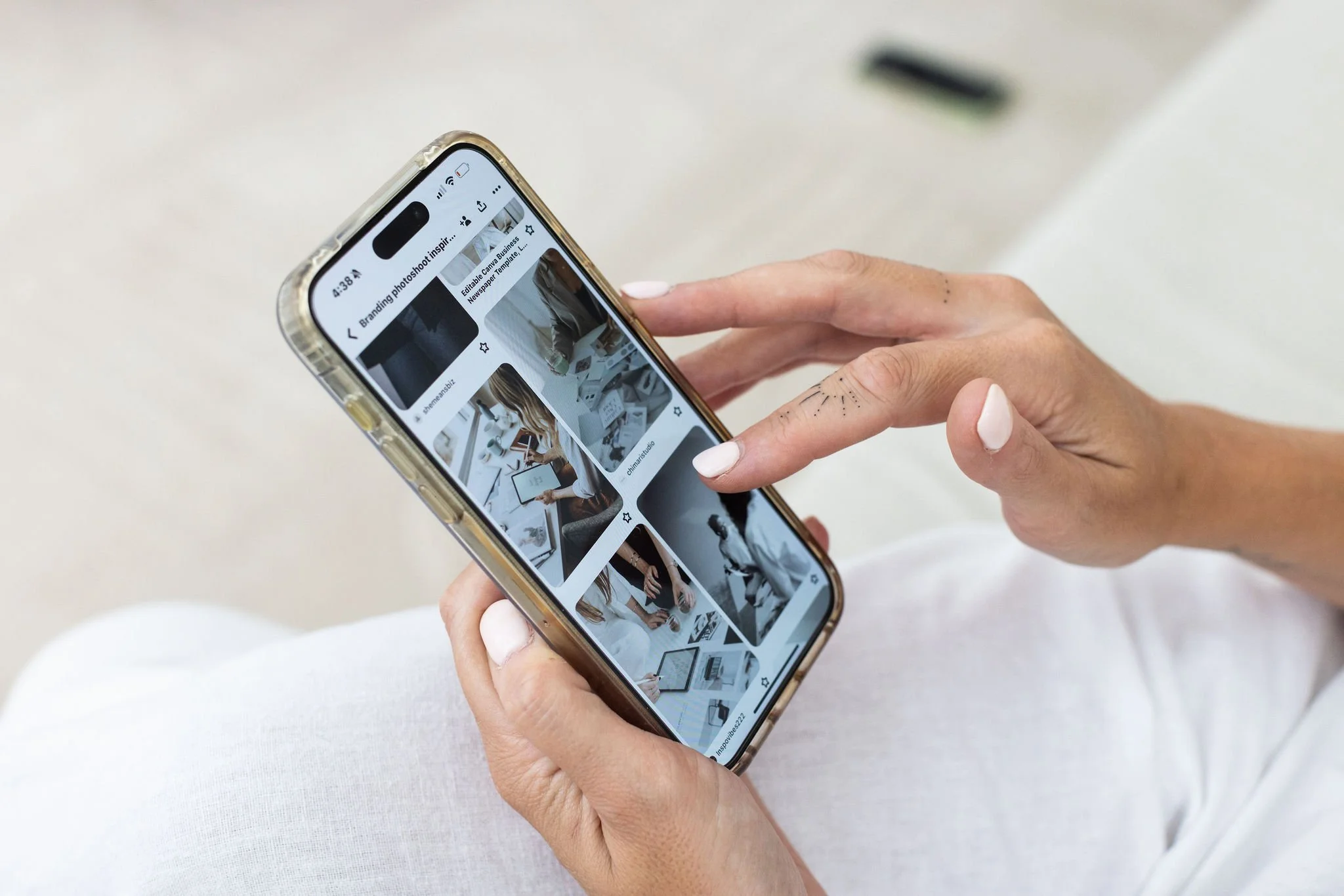 Person using a smartphone to browse a photo collection of modern office scenes.