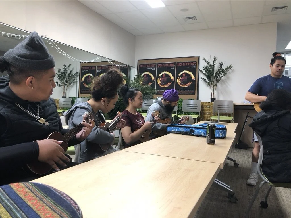Pacific Islanders learning the how to play the ukulele in a classroom