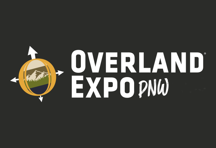 Rugged Luxury Motors at Overland Expo PNW logo featuring a globe with a mountain landscape and compass arrows on black background.
