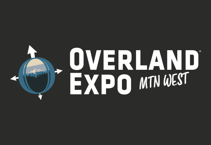 Rugged Luxury Motors at Overland Expo Mountain West logo with mountain and compass design.