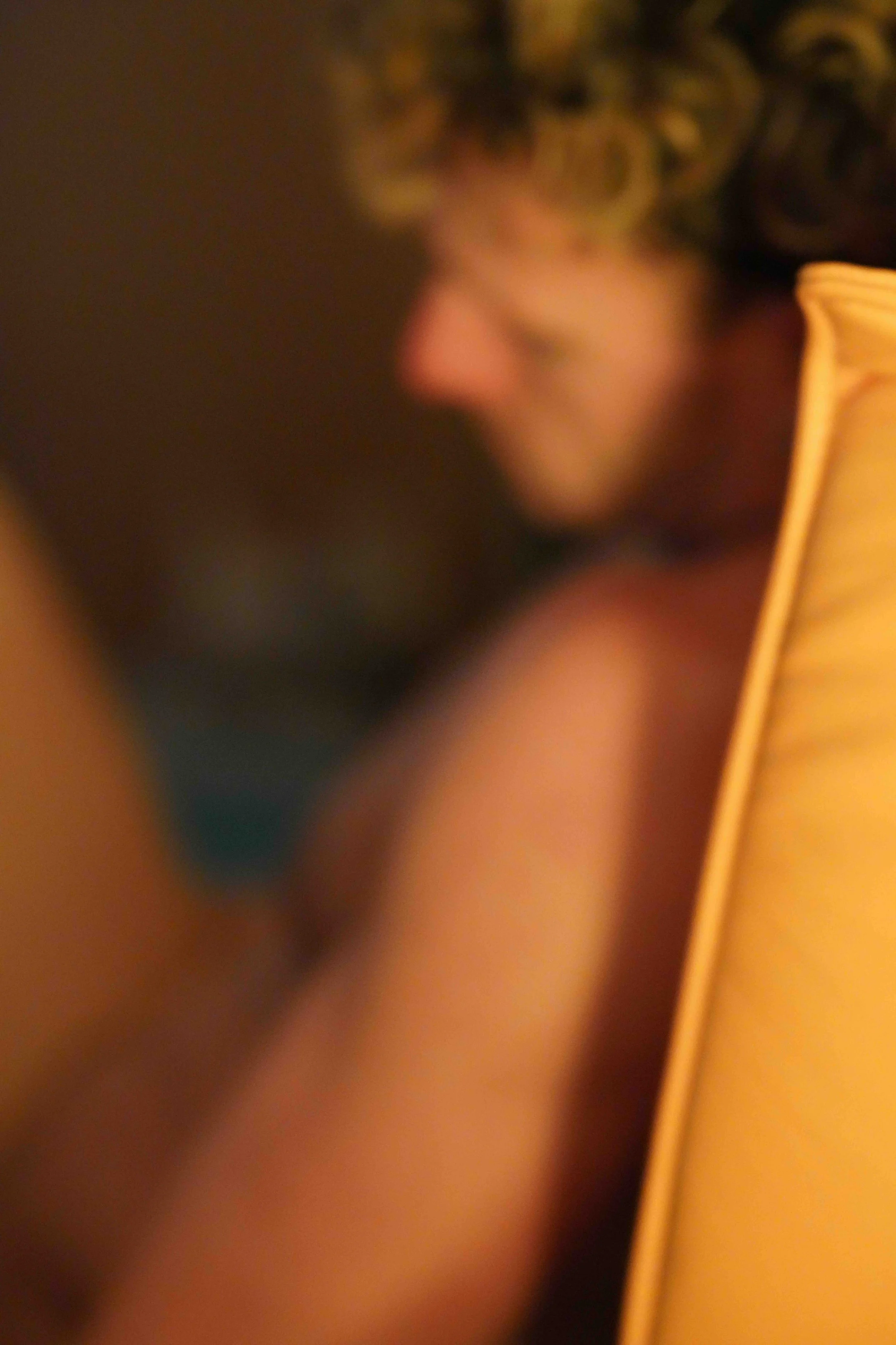 This is a blurry close-up of a person's face with glasses, with the face turned at an angle and out of focus.