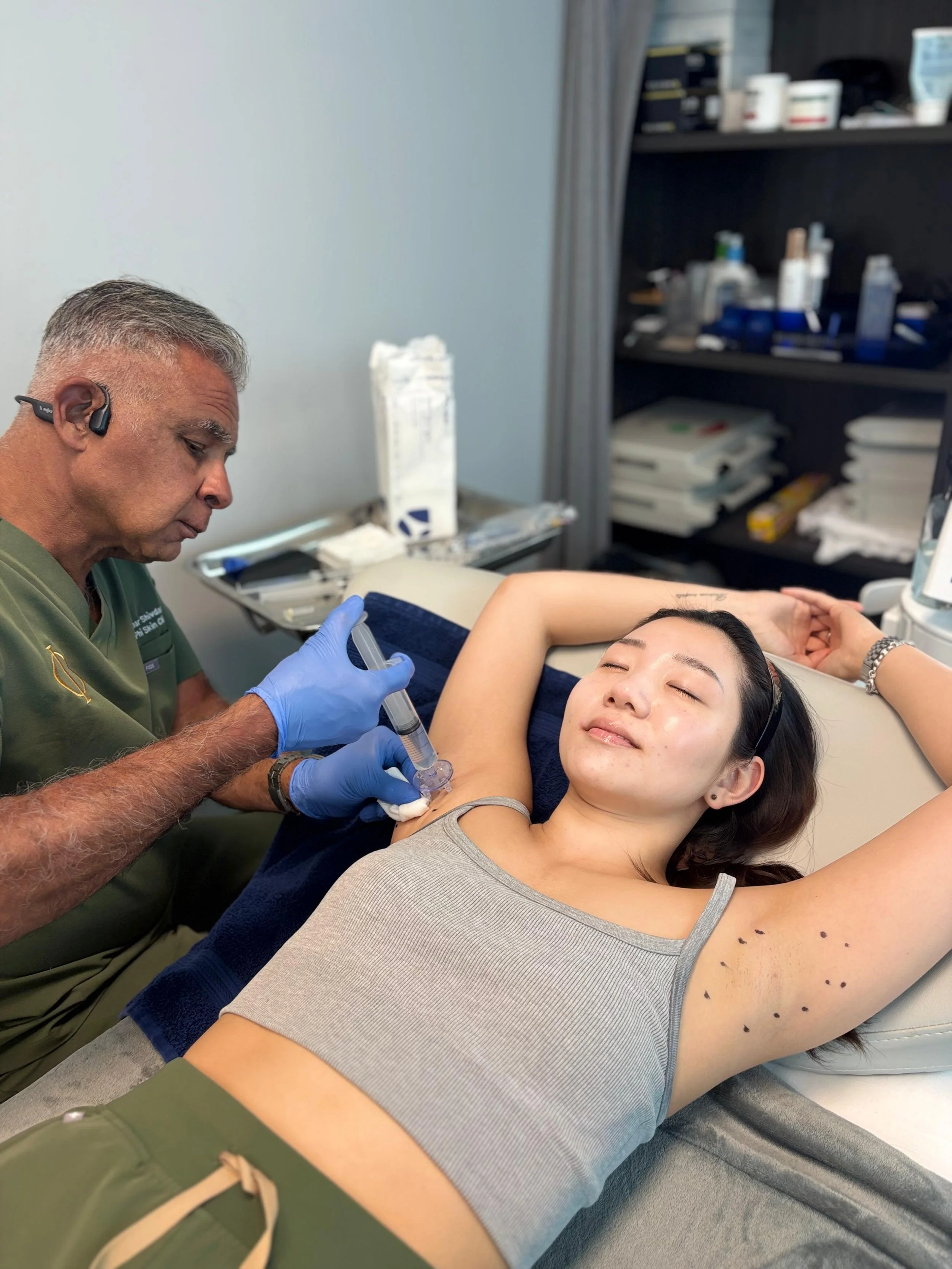 Dr. Kumar Shivdasani administering local anesthetic before Scarlett's miraDry treatment at Phi Skin Clinic in Vancouver, BC.