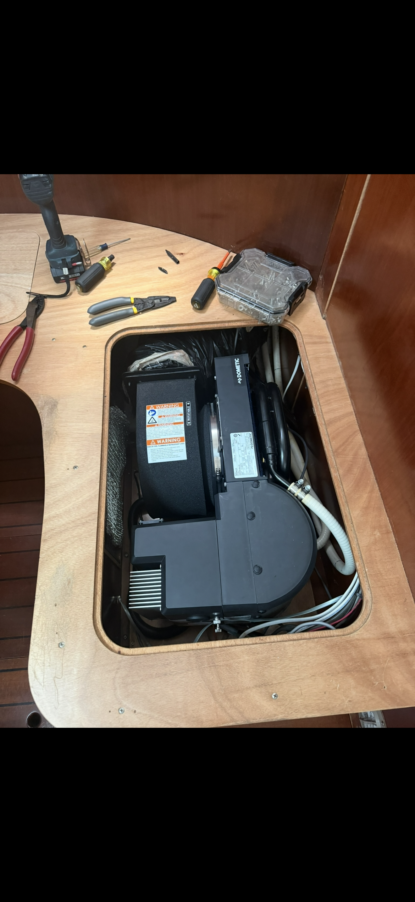 Boat engine with tools and parts on a wooden surface