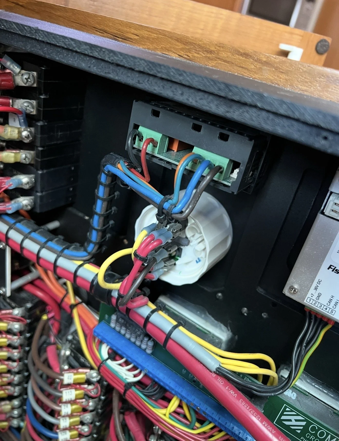 Close-up view of electrical wiring and components inside a control panel or electrical box, with colorful wires, terminals, and connectors.