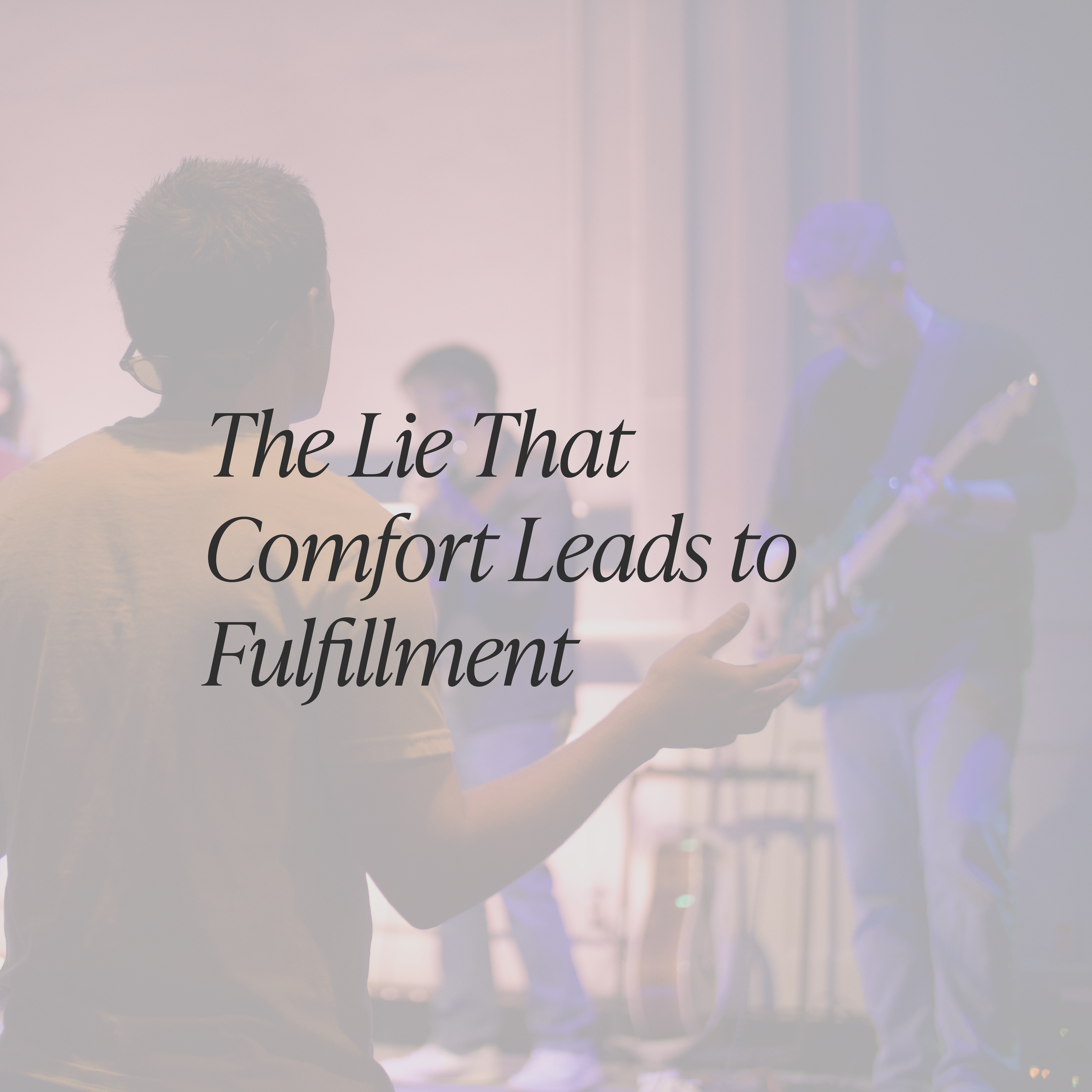 Blurry image of people engaging in a discussion or presentation, with overlaid text reading 'The Lie That Comfort Leads to Fulfillment'.