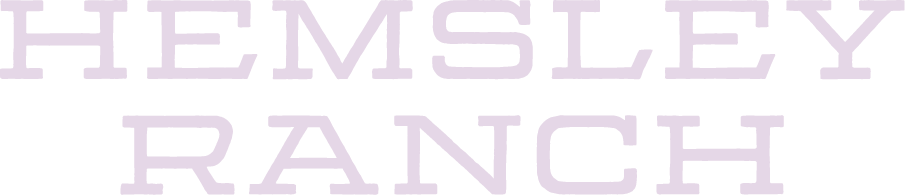 Close-up of the text 'HEMSLEY RANCH' in large, light purple letters on a black background.
