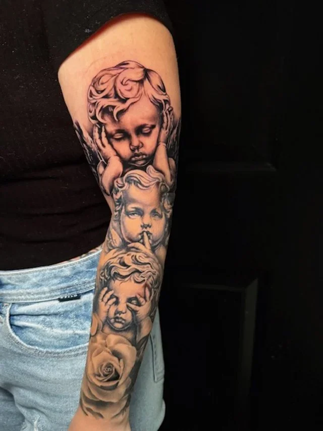 Tattoo sleeve featuring four cherubic children with different expressions, including a child with a finger over lips, and a rose at the bottom.