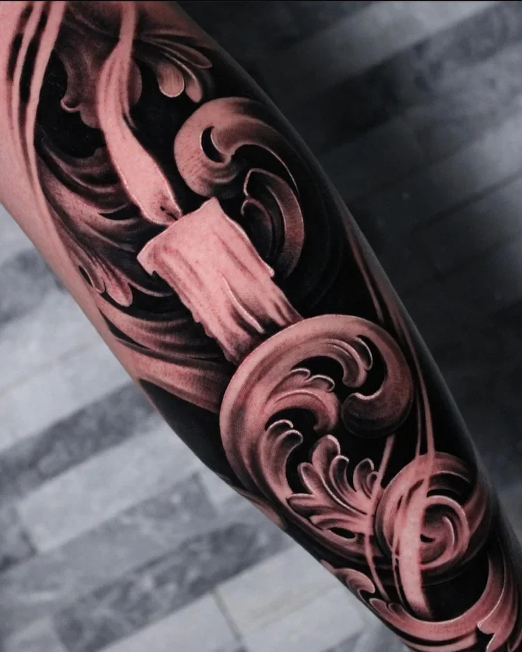 Close-up of a tattoo featuring pink and black swirling floral patterns on skin.